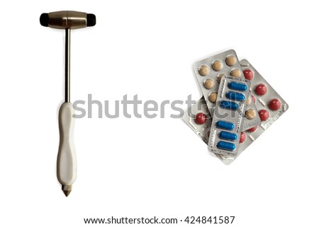 neurological hammer and stack of colorful pills in blisters isolated on white. background with copy space
