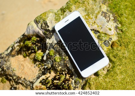 Closeup on smartphone on beach background. Top view style, outside fun for photo and video for journey
