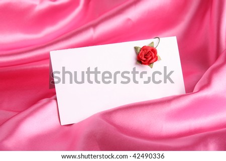 pink rose with  white card on  silk background