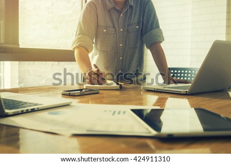 Start up businessman Determine Ideas Writing note ,People Meeting Design, working with calculator,business document laptop computer notebook,vintage tone Royalty-Free Stock Photo #424911310