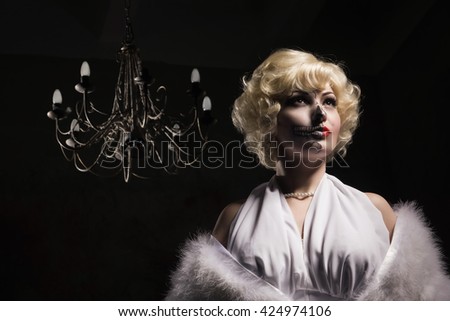 Beautiful woman with make-up skeleton in a dark gothic interior

