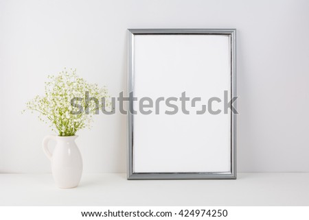 Silver frame mockup with white tender flowers. Frame mockup. Poster styled design. White frame mockup. 