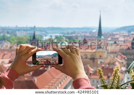 woman taking picture of Old Town in Prague with a smartphone
