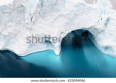 Arctic Icebergs Greenland in the arctic sea. You can easily see that iceberg is over the water surface, and below the water surface. Sometimes unbelievable that 90% of an iceberg is under water Royalty-Free Stock Photo #425094046