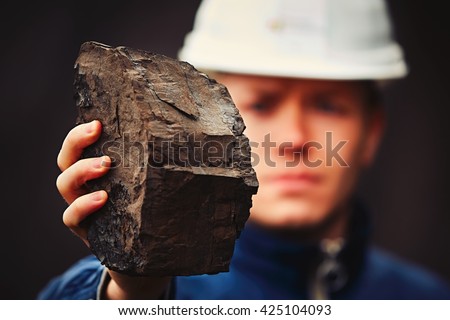 Worker is showing lignite - often referred to as brown coal Royalty-Free Stock Photo #425104093
