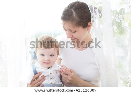 Happy cheerful family. Mother and baby kissing, laughing and hugging. Boy.