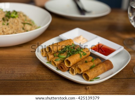 Lumpia Spring Rolls on Wooden Table in Restaurant Royalty-Free Stock Photo #425139379