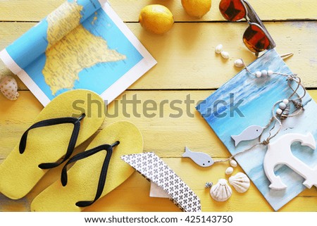 Beach accessories on yellow wooden background