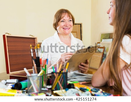Elderly woman artist in the process of creating a new picture