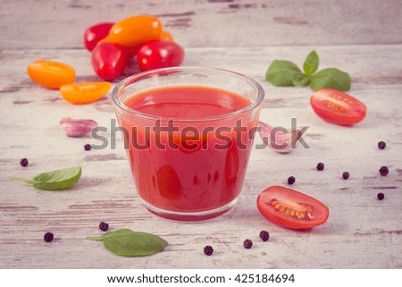 Vintage photo, Glass of fresh tomato juice and vegetables with spices on old rustic wooden background, healthy nutrition