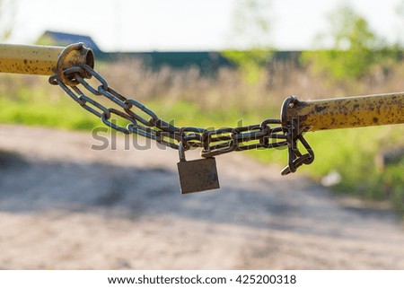 barrier in a field on the lock with a chain lock chain