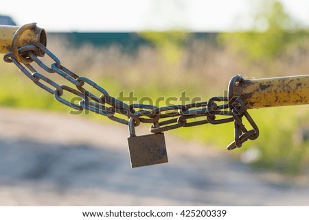 barrier in a field on the lock with a chain lock chain