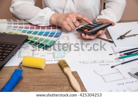 Professional worker drawing on house project with work tools