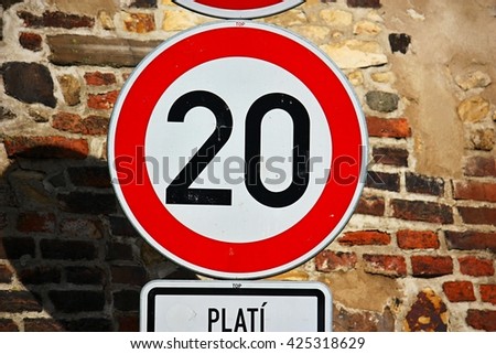Speed limit 20 km/h traffic sign against brick wall