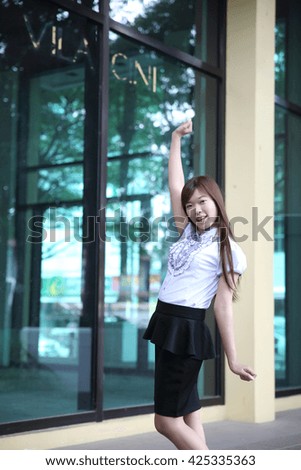 Young Asian business woman standing over office background