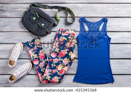 Denim handbag and tank top. White footwear and floral pants. Wooden showcase with clothing items. End of season sale.