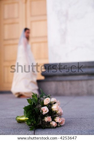 wedding bouquet in focus, bride at the background