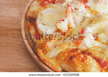Seafood pizza with sliced vegetables on rustic, vintage style wood background.with retro filter effect