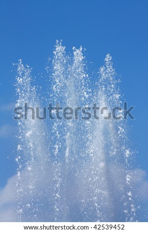 Water jet in a fountain in a bright sunny day