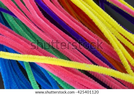 This is a photograph of Blue,Green,Purple,Orange,Pink and Yellow pipe cleaners/chenille stems background