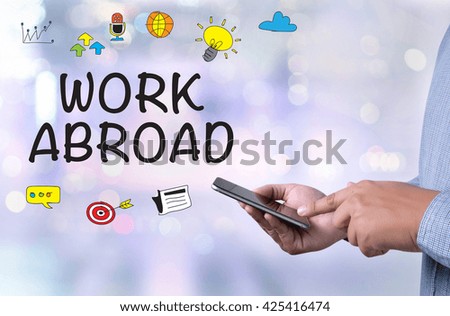 WORK ABROAD person holding a smartphone on blurred cityscape background