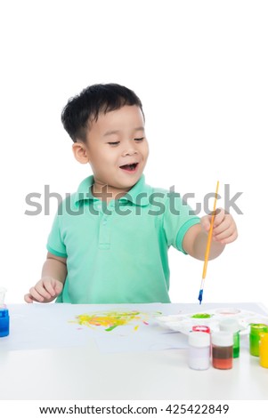 Portrait of handsome asian boy holding brush drawing. shooting in the studio on white background.