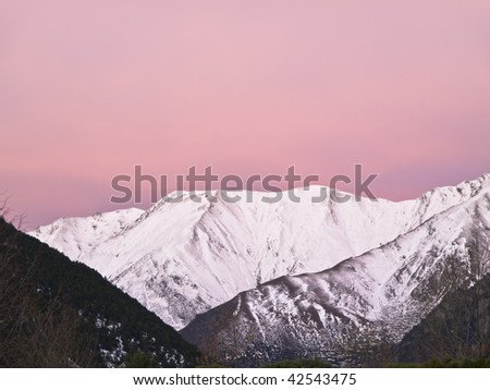 Snowy mountain peak. Photo taken with the purple light of dawn