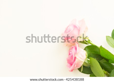 Styled desktop scene with pink fresh flowers, copy space on white table