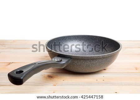 Frying pan on wooden background