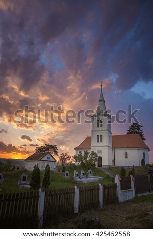 Faith sunset flames in the sky. Colorful cloudy sky over church. Dramatic Interpretation. Low key, dark background, spot lighting, and rich Old Masters