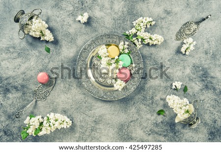 White lilac flowers and macaron cookies. Vintage silver plates. Retro style toned picture