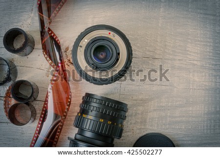The old optics for cameras and film lie on a wooden table