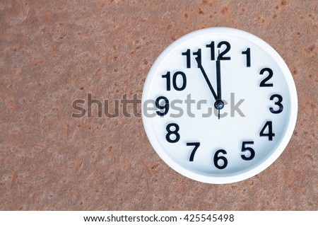 Clock show 5 minute to 12 am or pm on steel rusty background with copy space. clipping path in picture. Royalty-Free Stock Photo #425545498
