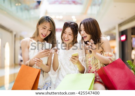 happy young woman  watching smart phone in shopping mall Royalty-Free Stock Photo #425547400