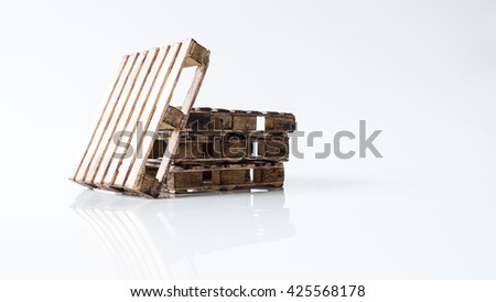 Mix stack of miniature wooden pallet. Concept of shipping and logistics. Isolated on white background. Slightly de-focused and close-up shot. Copy space.