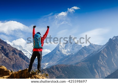 Hiker cheering elated and blissful with arms raised in the sky after hiking. Everest base camp trek Royalty-Free Stock Photo #425598697