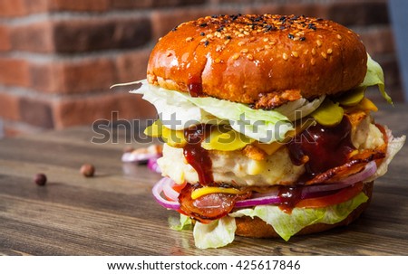 burger on wooden table against the background of a brick wall