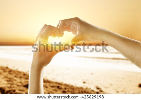 hands and heart and beach 