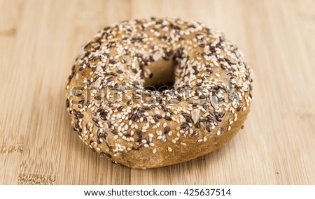 Wooden table with fresh baked wholemeal Bagels (selective focus; close-up shot)