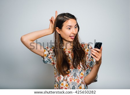brunette girl doing selfie photo on the phone isolated on a gray background