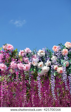 Background from many spring flowers on bottom side of photo under clear blue sky on sunny day vertical view