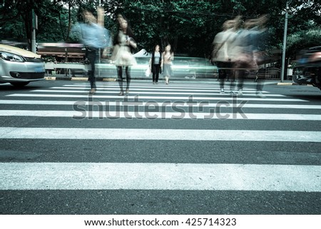 Crosswalk and pedestrian at modern city zebra crossing street in rainy day. Blur abstract.
