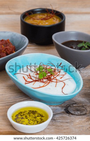 Variation of sauces and dips on wood background.