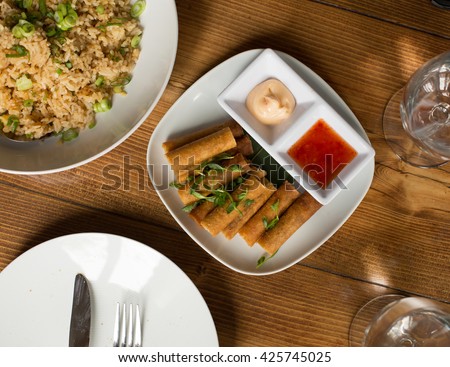 Lumpia Spring Rolls on Wooden Table in Restaurant Royalty-Free Stock Photo #425745025