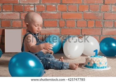 Portrait of baby boy celebrating her first birthday with cake