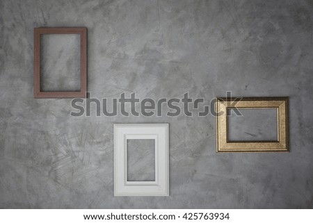 Picture frames on the grey wall.