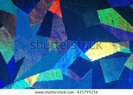 Colorful geometric patterns formed by light reflecting off a textured metallic surface