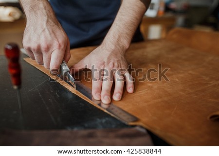 Close-up. Male hand master tanner in an apron for the work with the skin. Small business
