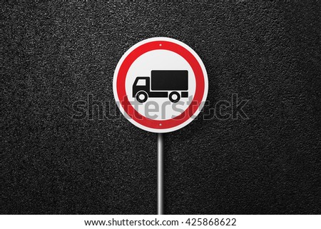 Road sign circular shape with a picture of the truck on a background of asphalt. The texture of the tarmac, top view.