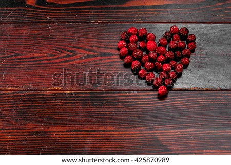 Dried rosehips , rose hips in a shape of heart,  hips on a wooden table, hips on a brown background, healthy berries full with vitamins. Healthcare concept